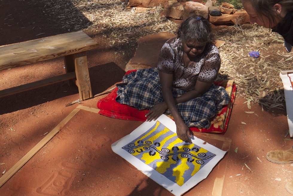 An Aboriginal woman with a dot painting