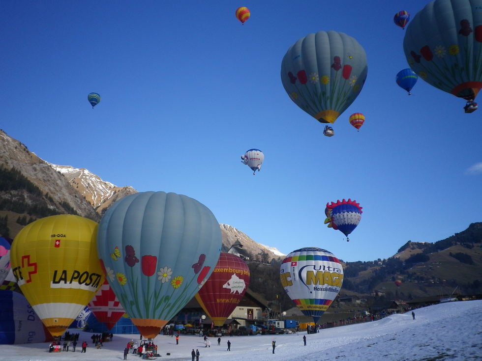 Half a dozen balloons float over the Alps as part of a major international festival