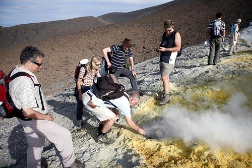 A group on the rim of Vulcano's crater of La Fossa volcano, dotted with yellow sulphur deposits from hot fumaroles on Vulcano Island, Italy. Courtesy Tom Pfeiffer/www.volcanodiscovery.com