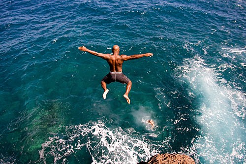 Daring divers leap off the craggy rocks at Hulopoe Bay, where crystal clear water also attracts snorkelers and swimmers.